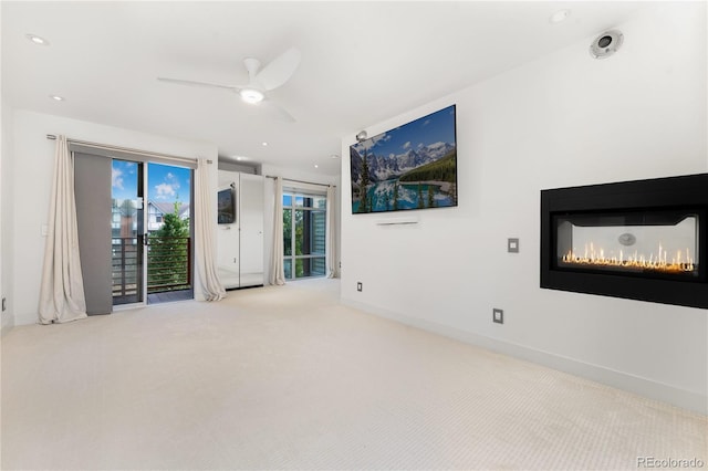 unfurnished living room featuring ceiling fan and light colored carpet