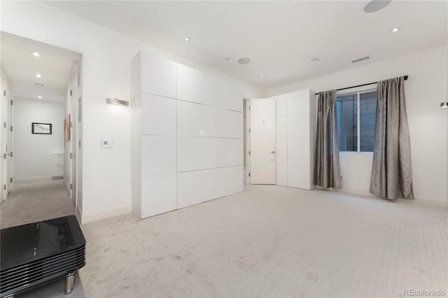 unfurnished bedroom featuring a closet and light colored carpet