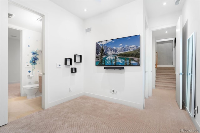 unfurnished bedroom with ensuite bathroom and light colored carpet