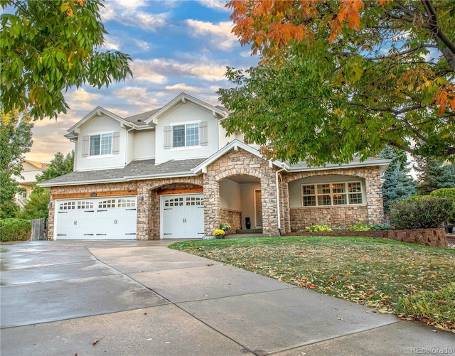 view of front of home with a garage and a lawn