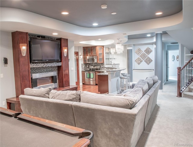 living room with light carpet and a raised ceiling