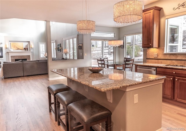 kitchen with dishwasher, a kitchen island, a kitchen breakfast bar, and decorative light fixtures