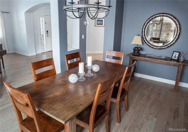 dining room with hardwood / wood-style floors and a notable chandelier