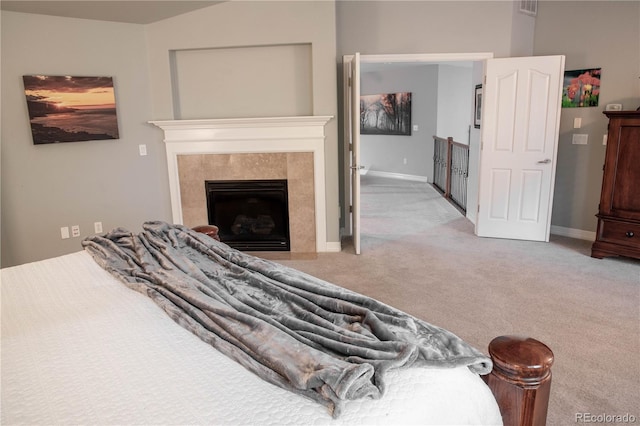 bedroom featuring light carpet and a high end fireplace