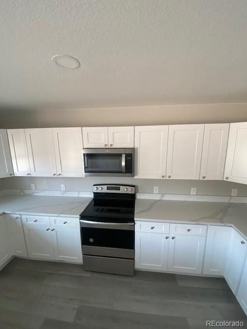 521 10th St, Fort Lupton, CO 80621 - kitchen with stainless steel appliances, white cabinetry, and a textured ceiling