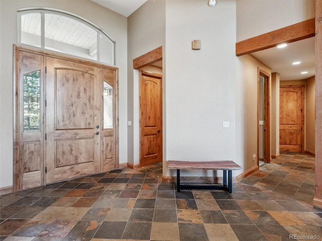 entrance foyer featuring stone tile floors and baseboards