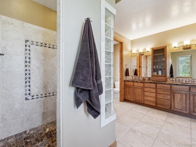 full bathroom featuring a sink, toilet, walk in shower, and double vanity