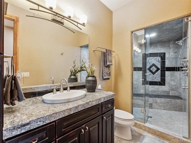 bathroom featuring vanity, toilet, a stall shower, and tile patterned flooring