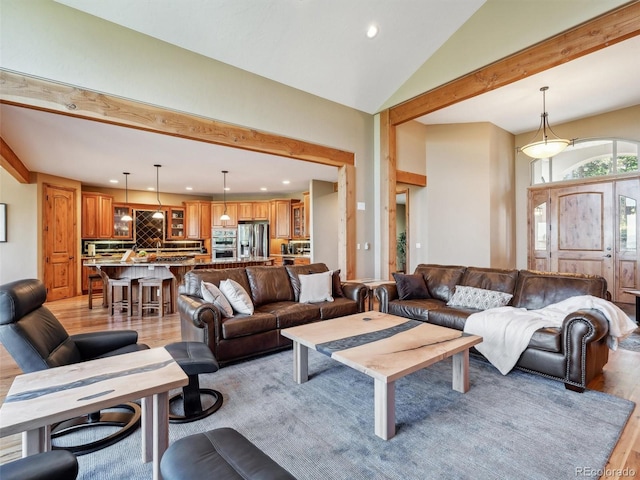 living room with light wood finished floors, beam ceiling, recessed lighting, and high vaulted ceiling