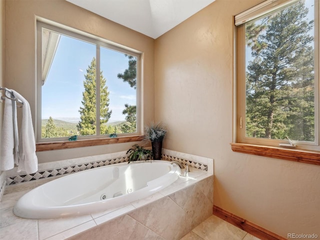 bathroom with tile patterned floors, baseboards, and a jetted tub