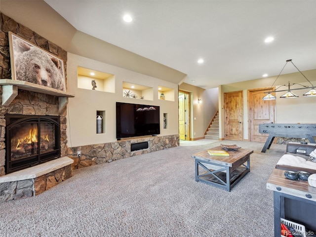 carpeted living area featuring recessed lighting, a fireplace, and stairs