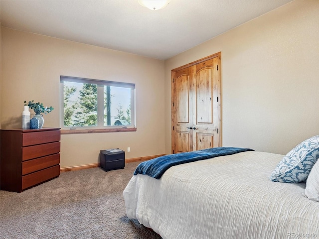 carpeted bedroom with baseboards and a closet