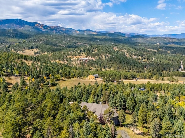 birds eye view of property with a mountain view and a wooded view