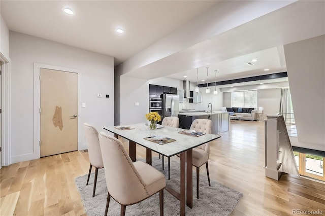 dining space with sink, plenty of natural light, and light wood-type flooring