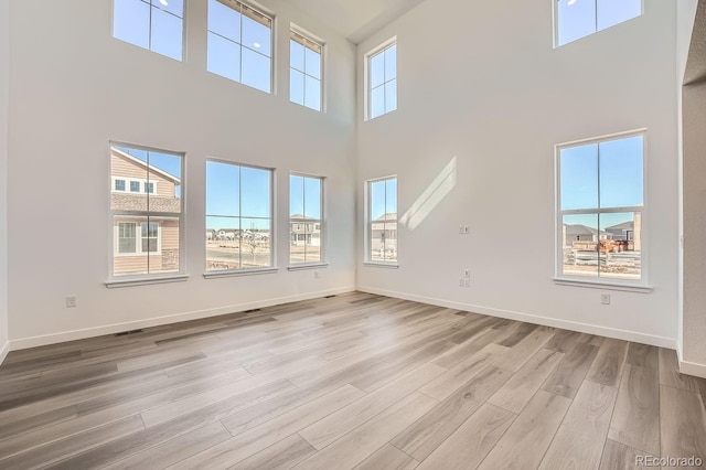 unfurnished living room with wood finished floors and baseboards