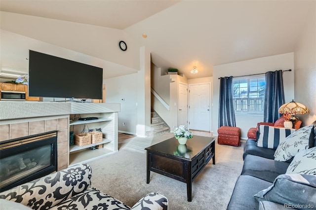 carpeted living room featuring a fireplace and vaulted ceiling