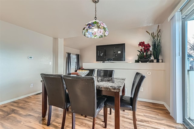 dining room with lofted ceiling and light wood-type flooring