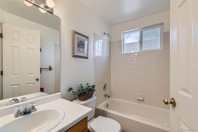 full bathroom featuring toilet, tiled shower / bath combo, and vanity