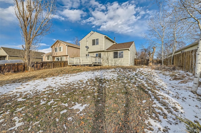 snow covered house with a wooden deck