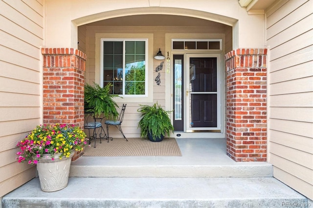 1026 Deer Clover Way, Castle Pines, CO 80108 - doorway to property featuring covered porch and brick siding