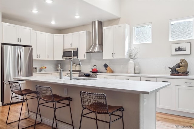 1026 Deer Clover Way, Castle Pines, CO 80108 - kitchen featuring wall chimney exhaust hood, appliances with stainless steel finishes, a sink, a breakfast bar, and white cabinets