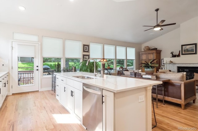 1026 Deer Clover Way, Castle Pines, CO 80108 - kitchen featuring stainless steel dishwasher, a sink, open floor plan, vaulted ceiling, and light wood-style floors