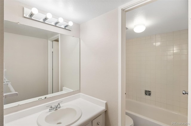 bathroom featuring bathtub / shower combination, vanity, toilet, and a textured ceiling