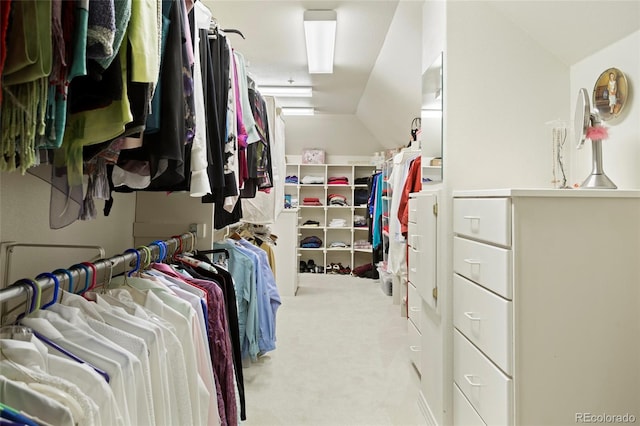 walk in closet featuring light carpet and lofted ceiling