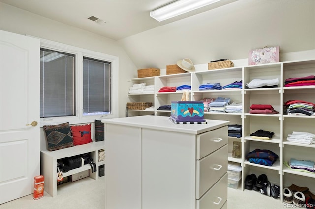 walk in closet featuring light carpet and vaulted ceiling