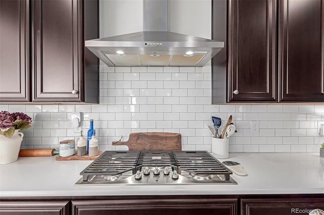 kitchen featuring backsplash, dark brown cabinets, exhaust hood, and stainless steel gas cooktop