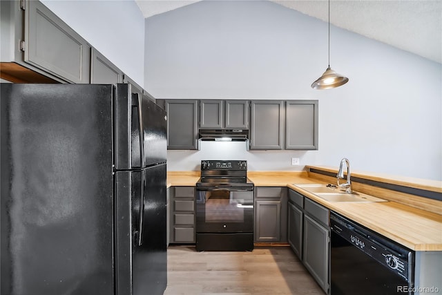 kitchen featuring light wood-type flooring, sink, black appliances, pendant lighting, and gray cabinets