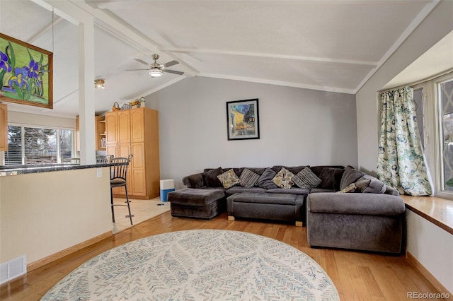 living room featuring light wood finished floors, visible vents, lofted ceiling with beams, and ceiling fan