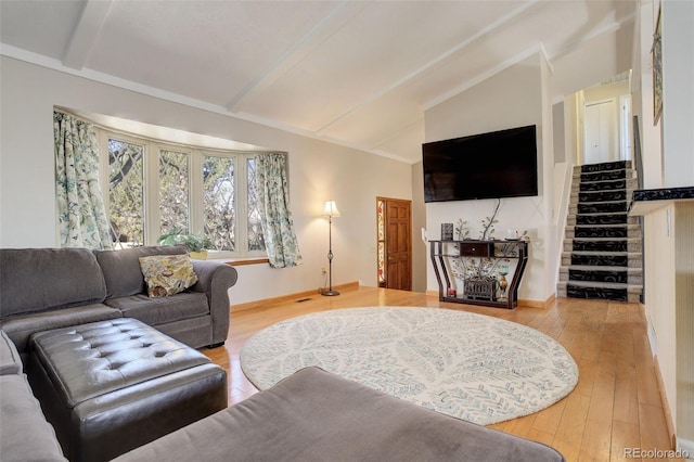 living area featuring lofted ceiling with beams, stairway, and hardwood / wood-style floors