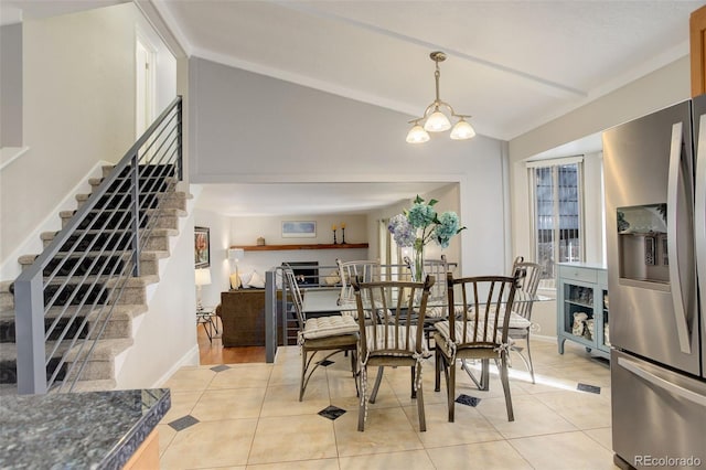 dining space featuring light tile patterned floors, baseboards, lofted ceiling, stairs, and a notable chandelier