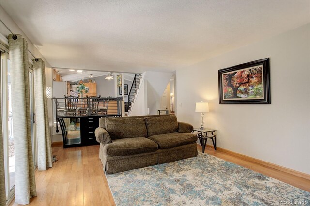 living room with stairway and light wood-style floors