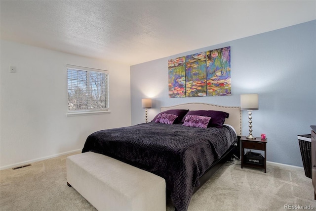 bedroom featuring carpet flooring, baseboards, visible vents, and a textured ceiling