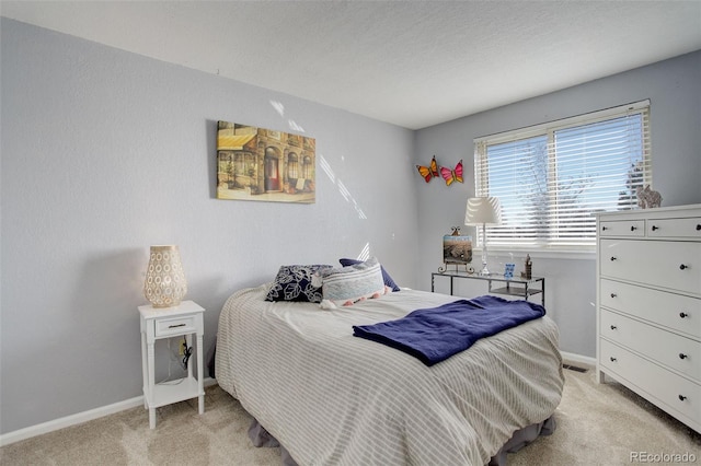 bedroom with light colored carpet and baseboards