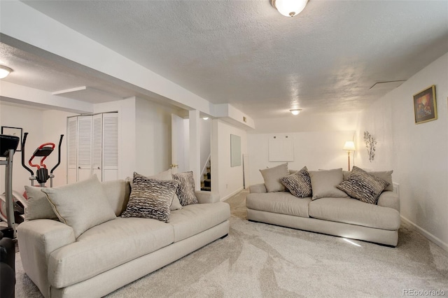 carpeted living area featuring baseboards, a textured ceiling, and stairs