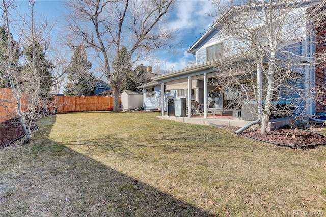 view of yard featuring a storage unit, a fenced backyard, a patio, and an outdoor structure