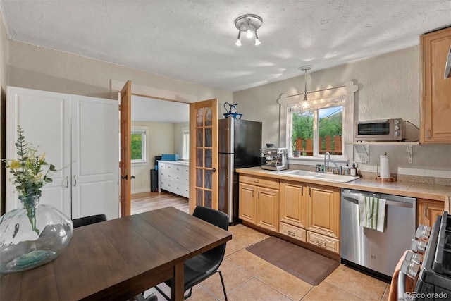 2874 SE Grapevine Rd, Idledale, CO 80453 - kitchen with appliances with stainless steel finishes, light countertops, light tile patterned floors, a textured ceiling, and light brown cabinets