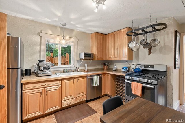 2874 SE Grapevine Rd, Idledale, CO 80453 - kitchen with appliances with stainless steel finishes, light tile patterned flooring, light countertops, decorative light fixtures, and a textured wall