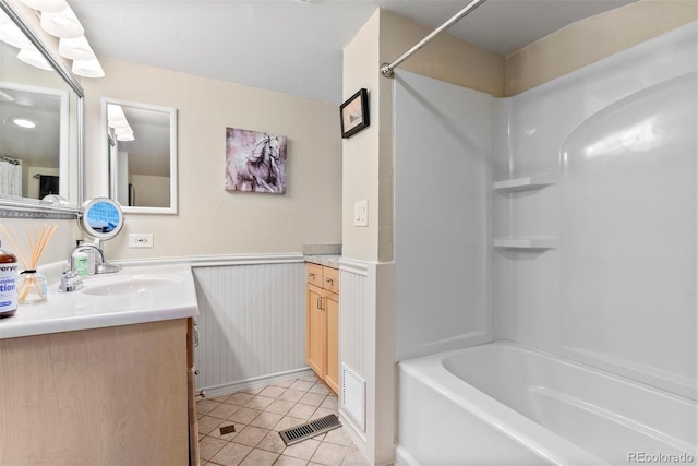 2874 SE Grapevine Rd, Idledale, CO 80453 - bathroom featuring vanity, tile patterned floors, shower / tub combination, and a wainscoted wall