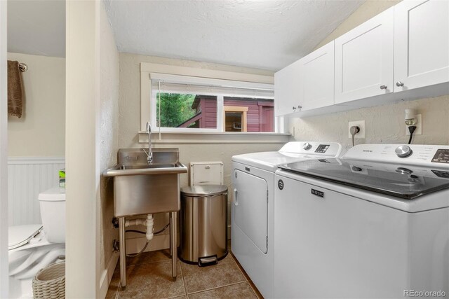 2874 SE Grapevine Rd, Idledale, CO 80453 - laundry area featuring independent washer and dryer, cabinet space, light tile patterned floors, and wainscoting