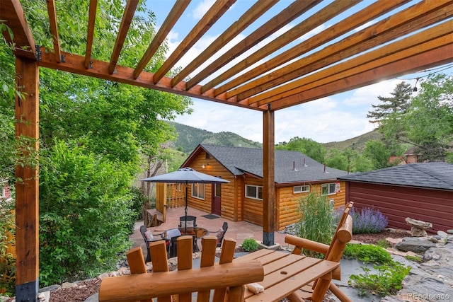 2874 SE Grapevine Rd, Idledale, CO 80453 - view of patio with outdoor dining area, a mountain view, and a pergola