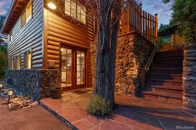 2874 SE Grapevine Rd, Idledale, CO 80453 - entrance to property featuring french doors, stone siding, a patio, and faux log siding