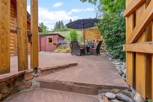 2874 SE Grapevine Rd, Idledale, CO 80453 - view of patio / terrace with outdoor dining area and a storage shed