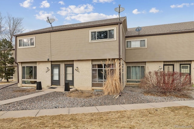 back of property featuring entry steps and brick siding