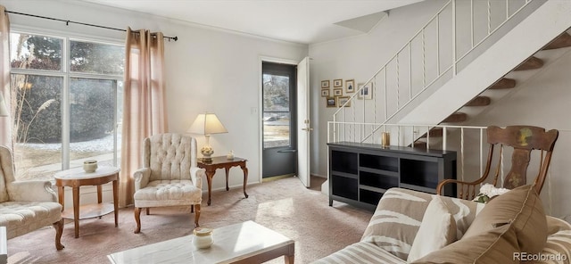 sitting room featuring carpet floors, a healthy amount of sunlight, and stairs