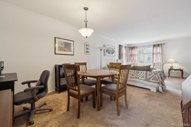 dining area featuring ornamental molding, light colored carpet, and baseboards