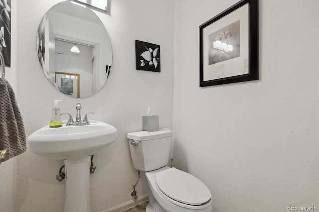 bathroom featuring toilet and baseboards